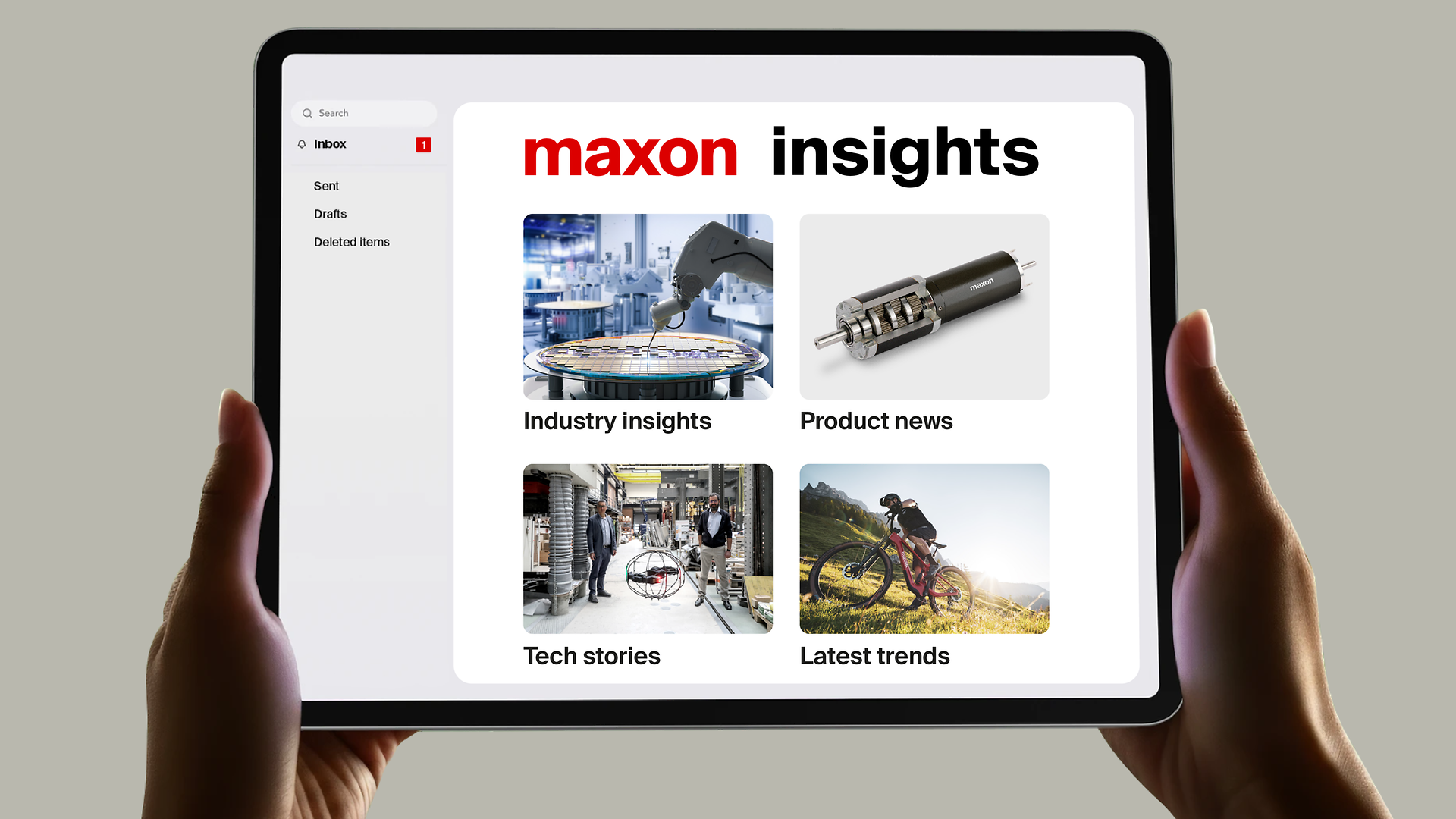 Hands holding a tablet displaying the maxon mail interface